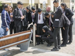 Marsden Heights pupils read the plaque on the side the bench